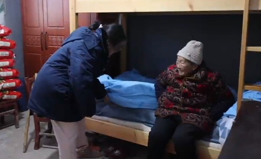 王雅晴帮外婆铺床，介绍温暖过冬情况。 杨迅摄